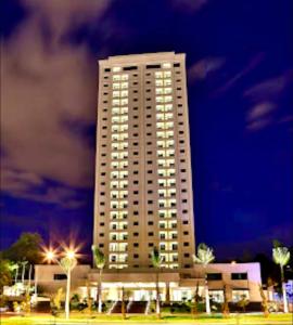 een hoog wit gebouw met lichten ervoor bij Flat Mont Blanc Premium in Ribeirão Preto +54 foto's