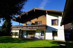 a large white house with a gambrel roof at Panorama Appartements in Itter