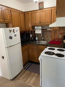 a kitchen with a white refrigerator and a stove at Cozy One-Bedroom Retreat in the Heart of Smithtown in Smithtown