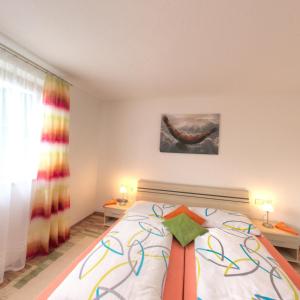 a bedroom with a bed with a colorful bow on it at Bergadler in Iselsberg