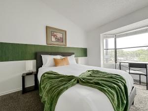 オースティンにあるSleepover 1BD 1BA Austin TX Apartmentsの緑のヘッドボードが付いた大きなベッドのある寝室