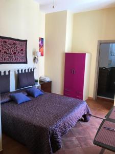 sypialnia z fioletowym łóżkiem i fioletową komodą w obiekcie Mondello Room w mieście Mondello