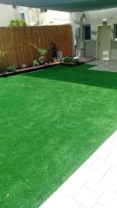 a yard with green grass in a house at Krayot Studio Apartments in Qiryat Bialik