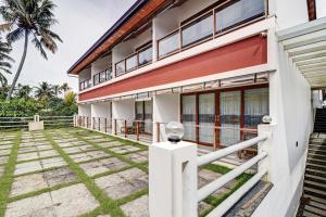 an exterior view of a house with a palm tree at OAK Edassery's Sealine Villa Stay in Cochin +118 photos