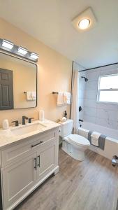 a bathroom with a sink and a toilet and a tub at Wanderlust Inn in Ocean Shores