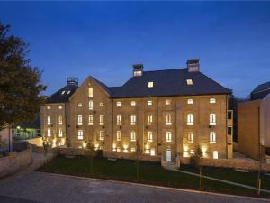a large building with lights on it at night at 2-Bed I Converted Malt House I Rare Find I Parking in Newmarket