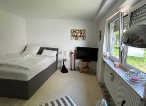 a bedroom with a bed and a television in it at Schicke Einliegerwohnung in Karben