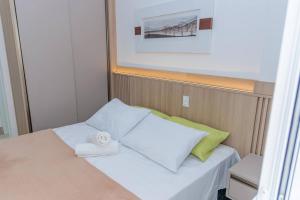 a small room with a bed with a towel on it at 250m do Mar | Piscina e Roupas de Cama in Bertioga +141 photos