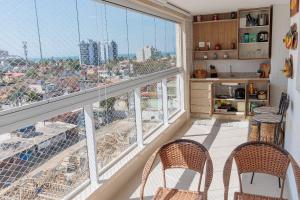 a room with two chairs and two large windows at 250m do Mar | Piscina e Roupas de Cama in Bertioga