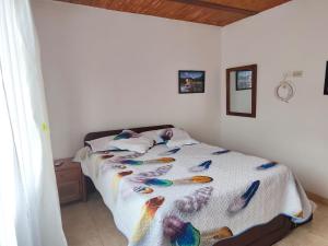 ein Schlafzimmer mit einem Bett mit Vögeln darauf in der Unterkunft Casa Linda in Villa de Leyva