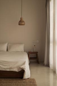 a bedroom with a bed and a pendant light at Nalu Mirissa in Mirissa