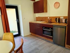 a kitchen with brown cabinets and a table and a window at La Cornaline in Le Chalon