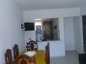 a dining room with a table and chairs and a television at Privê Areias Douradas in Peroba