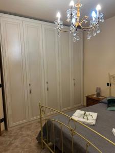 a bedroom with a bed and a chandelier at L' Antica Sosta in Abbadia San Salvatore