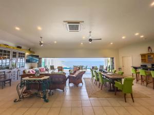 a living room with tables and chairs and a view of the ocean at Oceans Edge Villa in Solitude
