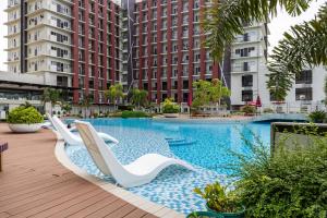 a swimming pool with lounge chairs and buildings at Cebu Serene Quarters with Pool View in Mactan Island