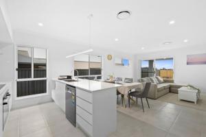 une cuisine et un salon avec un canapé et une table dans l'établissement Family Retreat 4BR&2BA Parking in Private Garden Highbury Court, à Park Ridge