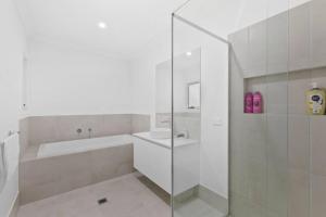 une salle de bain avec une douche, une baignoire et un lavabo dans l'établissement Family Retreat 4BR&2BA Parking in Private Garden Highbury Court, à Park Ridge