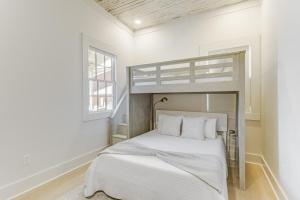 a bedroom with a bunk bed in a white room at Chelles in Bay St. Louis in Bay Saint Louis