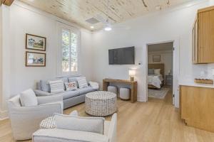 a living room with a couch and chairs and a tv at Chelles in Bay St. Louis in Bay Saint Louis