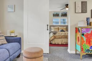 a living room with a bed and a blue couch at Cozy 1BR Studio Cottage in Avondale Prime Location in Miramar Terrace