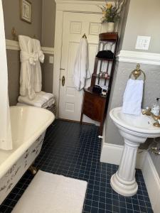 a bathroom with a tub and a sink and a toilet at The Martha Dale at The Judges Chambers in Guthrie