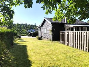 4 star holiday home in BORÅS في بوراس: منزل به سياج بجوار ساحة