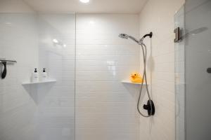 Un baño con ducha con un patito de goma amarillo en un estante. en Fast Wifi Dopest Studio SLC, en South Salt Lake