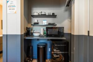 Una pequeña cocina con una isla azul con microondas. en Fast Wifi Dopest Studio SLC, en South Salt Lake