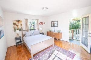 a bedroom with a white bed and a rug at The Marlowe Family Suite in Santa Barbara