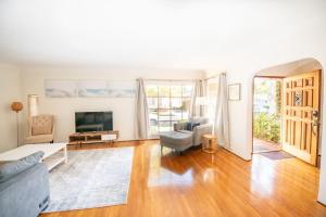 a living room with a couch and a tv at The Marlowe Family Suite in Santa Barbara