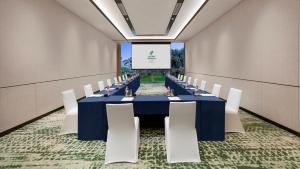 een vergaderzaal met een lange tafel en witte stoelen bij Holiday Inn Beihai Silver Beach in Beihai