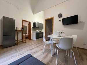 a living room with a table and chairs and a kitchen at Villa Don Minzoni in Misterbianco +4 photos