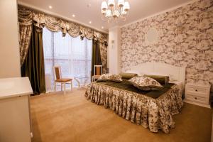 a bedroom with a large bed with a chandelier at Hotel Teta Kropotkin in Kropotkin