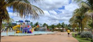 a person walking by a pool with a water park at Eco Park Campo Grande Hotel in Campo Grande