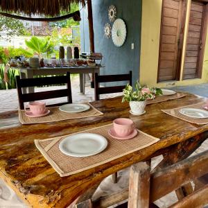 a wooden table with plates and bowls on it at Santo Amaro Chalés in Santo Amaro +92 photos