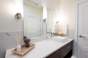 a white bathroom with a sink and a mirror at Palafox Oasis in Baptist Hospital Heliport +21 photos