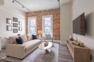 Una sala de estar con un sofá y un televisor. en Downtown Loft on Palafox Street, en Baptist Hospital Heliport