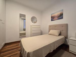 a white bedroom with a bed and a mirror at Apartamento Lugo centro muralla in Lugo