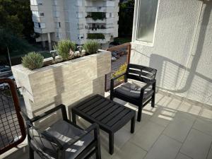 three chairs and a table on a balcony at Apartman Tea in Čapljina