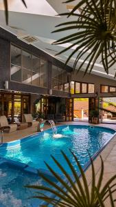 a large swimming pool with a fountain in a building at ANCA RESORT & SPA - Transilvania in Sălciua de Jos