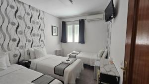 a hotel room with two beds and a television at CH Chelo in Madrid +26 photos