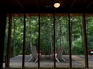 two chairs and a table on a deck with trees at Okatse Life, Village Kinchkha in Kinchkha-Perdi +12 photos
