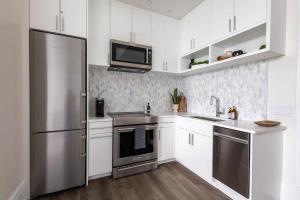 een keuken met witte kasten en een roestvrijstalen koelkast bij Chestnut Chateau in Baptist Hospital Heliport +13 foto's