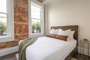 een slaapkamer met een wit bed en 2 ramen bij Chestnut Chateau in Baptist Hospital Heliport