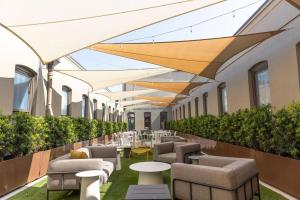 een gebouw met stoelen en tafels en een rij parasols bij Chestnut Chateau in Baptist Hospital Heliport