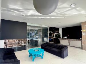 a living room with two couches and a blue table at Hotel Plaza Sport in Bogotá