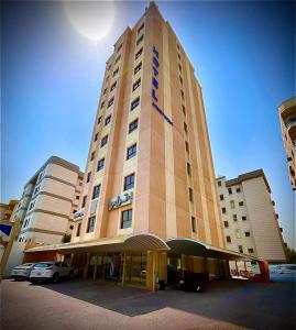 a tall building with a sign on top of it at Terrace Furnished Apartments- Salmiya in Kuwait