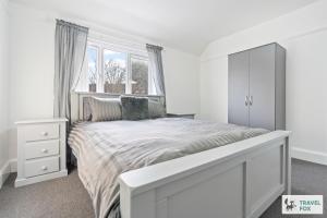 a white bedroom with a bed and a window at Abbie's House in Nottingham