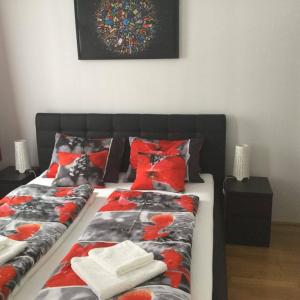 ブダペストにあるLia's Apartment in Gozsdu and Free Parkingの赤い枕と壁の絵が付いたベッド2台